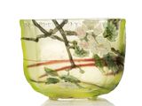 un bol en verre rempli d'eau et de fleurs, posé sur une surface blanche