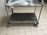 a kitchen with a metal cart with a lot of stuff on it