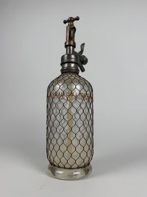 une bouteille en verre à l'ancienne, surmontée d'un oiseau