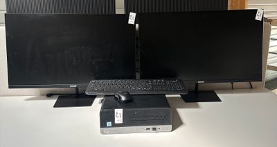 two computer monitors and a keyboard on a desk