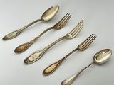 six fourchettes et cuillères sont alignées sur une surface blanche