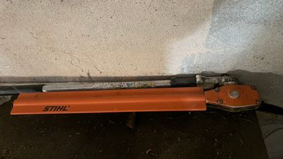 une agrafeuse orange posée sur une table près d'un mur