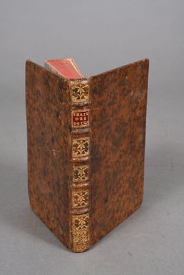 an old book sitting on top of a table next to a gray wall