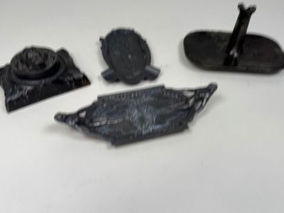 three pieces of metal on a white surface