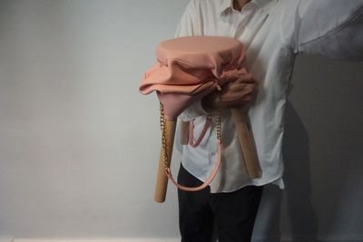 une femme tenant un sac rose et une batte de baseball
