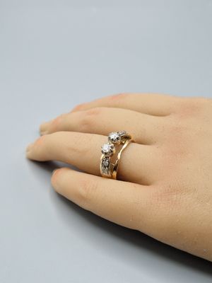une image représentant la main d'une femme portant une bague en diamant