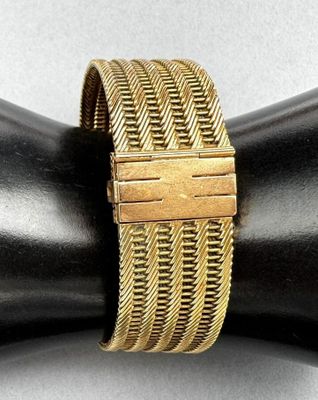 a close up of a gold bracelet on a mannequin arm