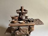 an antique cast iron stove with a bowl and pan on top of it
