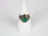 a close up of a ring with a green stone in it