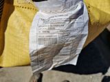 un sac de nourriture posé par terre près des pieds d'une personne