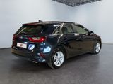 the back end of a black car in a showroom
