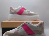 a pair of pink and white sneakers on top of a box