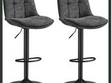 une paire de tabourets de bar gris posés sur un piètement en métal