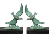 pair of green bird sculptures on black bases on a white background