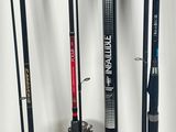 several different types of fishing rods are lined up against a white wall