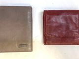 two leather wallets sitting next to each other on a white surface