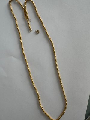a gold necklace with a gold chain and a gold bead necklace