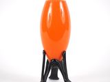 an orange vase sitting on a black stand against a white background