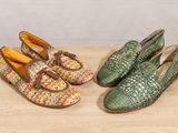 two pairs of woven shoes sitting on top of a wooden table