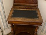 a small wooden desk with a chalk board on top of it