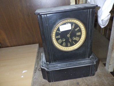 a black clock sitting on top of a wooden table
