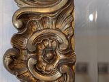 a mirror that has a gold frame with a dragon on it