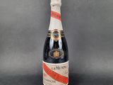 a bottle of champagne with a red ribbon around it