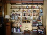 a book shelf with many books on it in a room