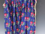 a blue skirt with pink flowers on it hanging on a hanger