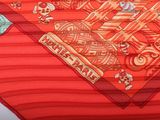 a close up of a red scarf with a design on it
