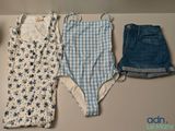 trois vêtements posés sur une table, à côté d'une tasse