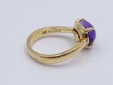 a close up of a gold ring with a purple stone