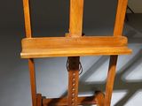 a wooden easel with a wooden seat on a white floor