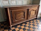 a large wooden cabinet in a room with a checkered floor