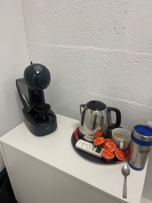 une cafetière posée sur une étagère blanche, à côté d'une cafetière