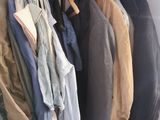 a lot of clothes hanging on a rack in a closet