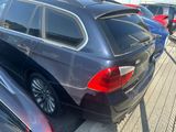 un SUV BMW noir garé sur un parking avec d'autres voitures