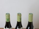 three bottles of wine sitting on top of a table next to each other