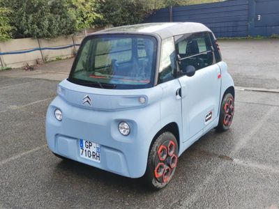 a small blue car parked in a parking lot