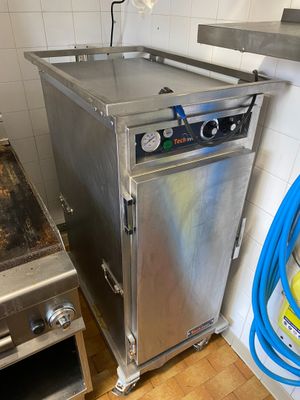 un four en acier inoxydable avec un tuyau bleu à côté