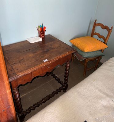 a small wooden table with a chair next to it