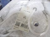 a white bag with a label on it sitting on a bed