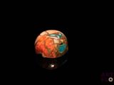 a close up of a red and blue ball on a black surface