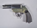 un pistolet posé sur une surface blanche