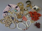 many different types of necklaces and bracelets laid out on a table