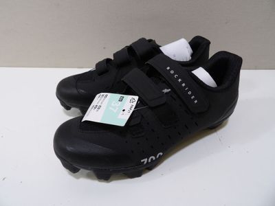 the shoes are black and white with a green tag on them