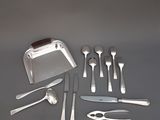un service d'argenterie posé sur une table, comprenant un couteau, une fourchette, une cuillère et un repose-couteau