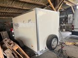 a trailer with a trailer attached to it in a garage