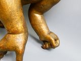 une statue en or représentant un bébé assis par terre