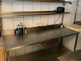 une cuisine avec des plans de travail en inox et un évier